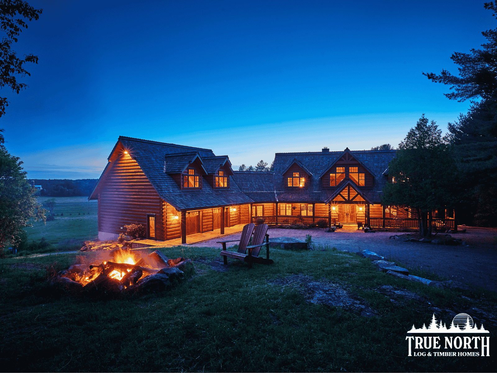 The Citadel by True North Log & Timber Homes, a log home with stunning timber frame elements like the front entrance and wraparound porch.